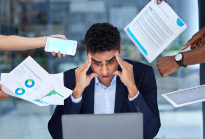 burnout Überforderung Zeitdruck ein junger Büroangestellter ist von seinen Aufgaben überfordert