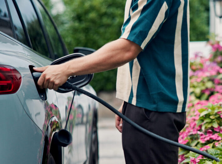 Ein Mann betankt sein Elektroauto mit Strom